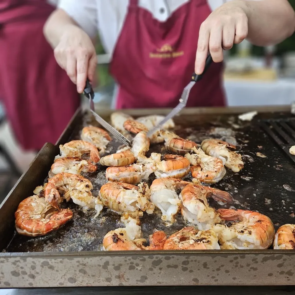 Garnelen auf der heißen Grillplatte beim Live-Grill im vorderen Bereich der Feierscheune