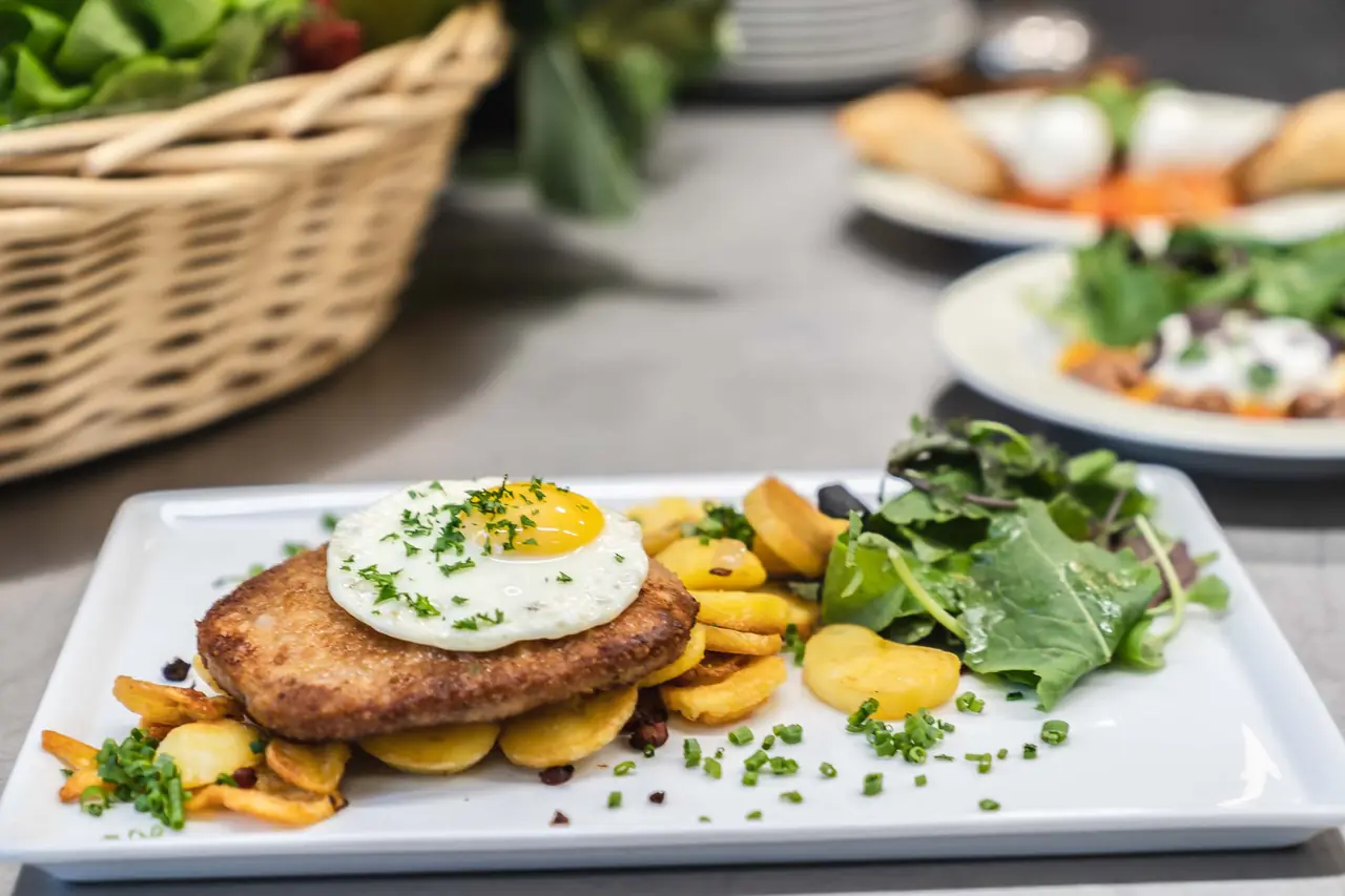 Schnitzel Hamburger Art mit Spiegelei, Bratkartoffeln und Salat im Restaurant des Deutschen Hauses