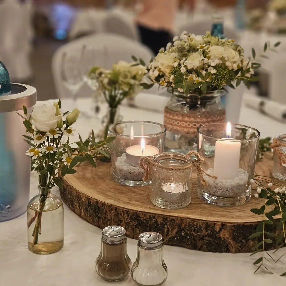 Weiße Rosen und Kamille mit Kerzenlicht auf einer Baumscheibe, Tischdekoration einer Hochzeit im Deutschen Haus Arendsee